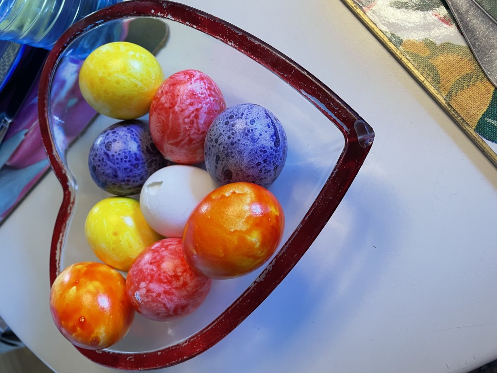 Färgade påskägg i hjärtformad glasskål