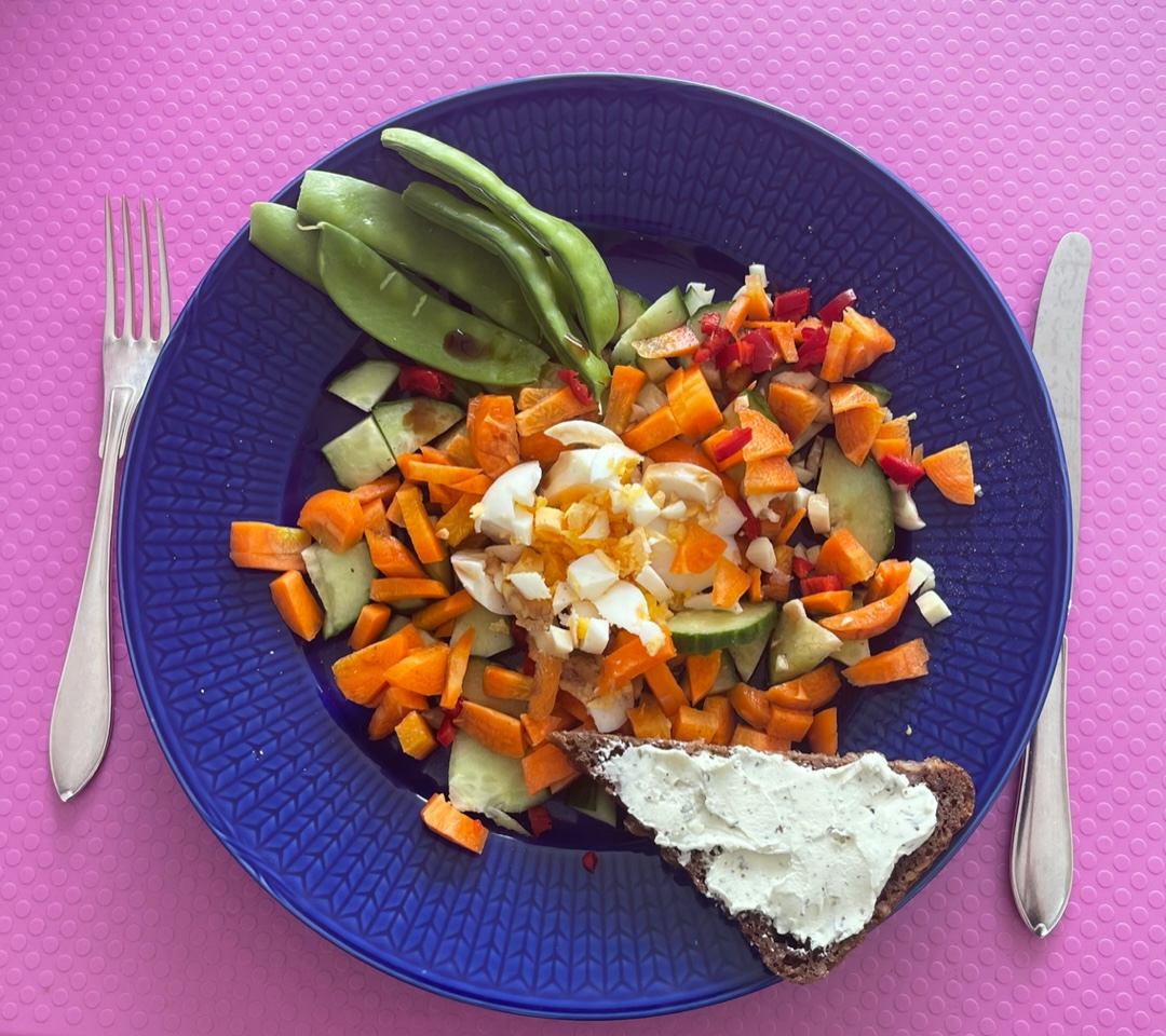 Färgglad grönsaks-mat på blå keramik-tallrik