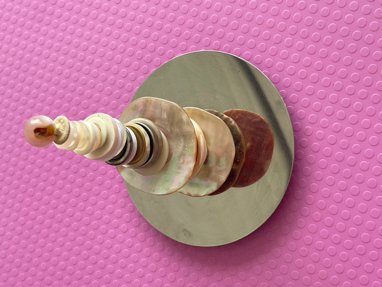 Skulptur av plast och pärlemo-knappar