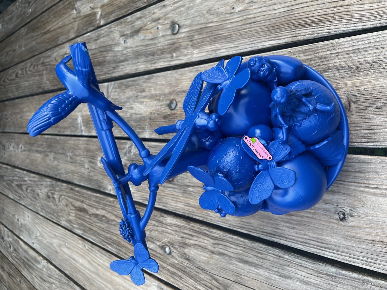 Blå skultur av dock-delar, fjärillar och en ovanlig fönsterkrapa.